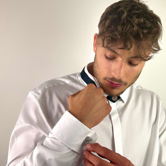 A man adjusting his cuff, wearing the Harlem Tie closed at the collar